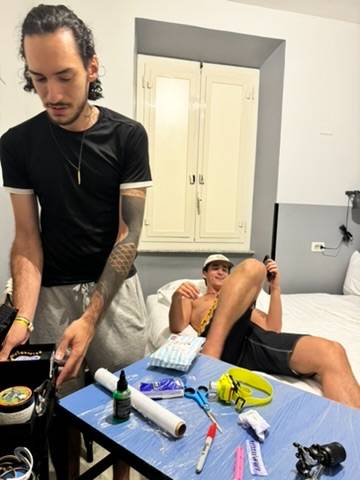 Artist setting up his kit on a table in the hostel room