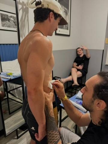 Artist wiping down the fresh tattoo