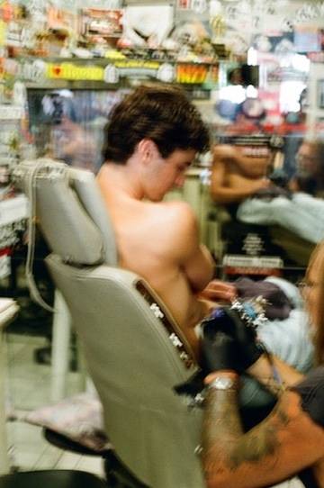 Getting tattooed in a shop, shot on film